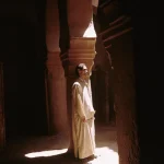 Homme debout dans une lumière tamisée à l'intérieur d'un bâtiment ancien