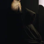 Statue religieuse et moine en habit traditionnel dans l'ombre