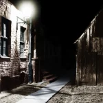 Rue sombre avec lampadaire éclairant le trottoir