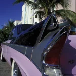 Voiture Américaine Vintage Rose Devant un Hôtel