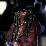 Femme en tenue bohémienne avec des tresses colorées et un chapeau
