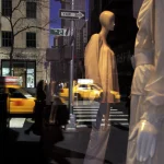 Vitrine de magasin avec mannequins et reflets urbains