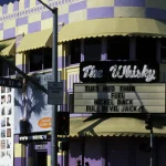 Façade colorée du Whisky a Go Go avec deux personnes au coin de la rue