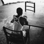 Homme assis seul à une table en bois, en noir et blanc